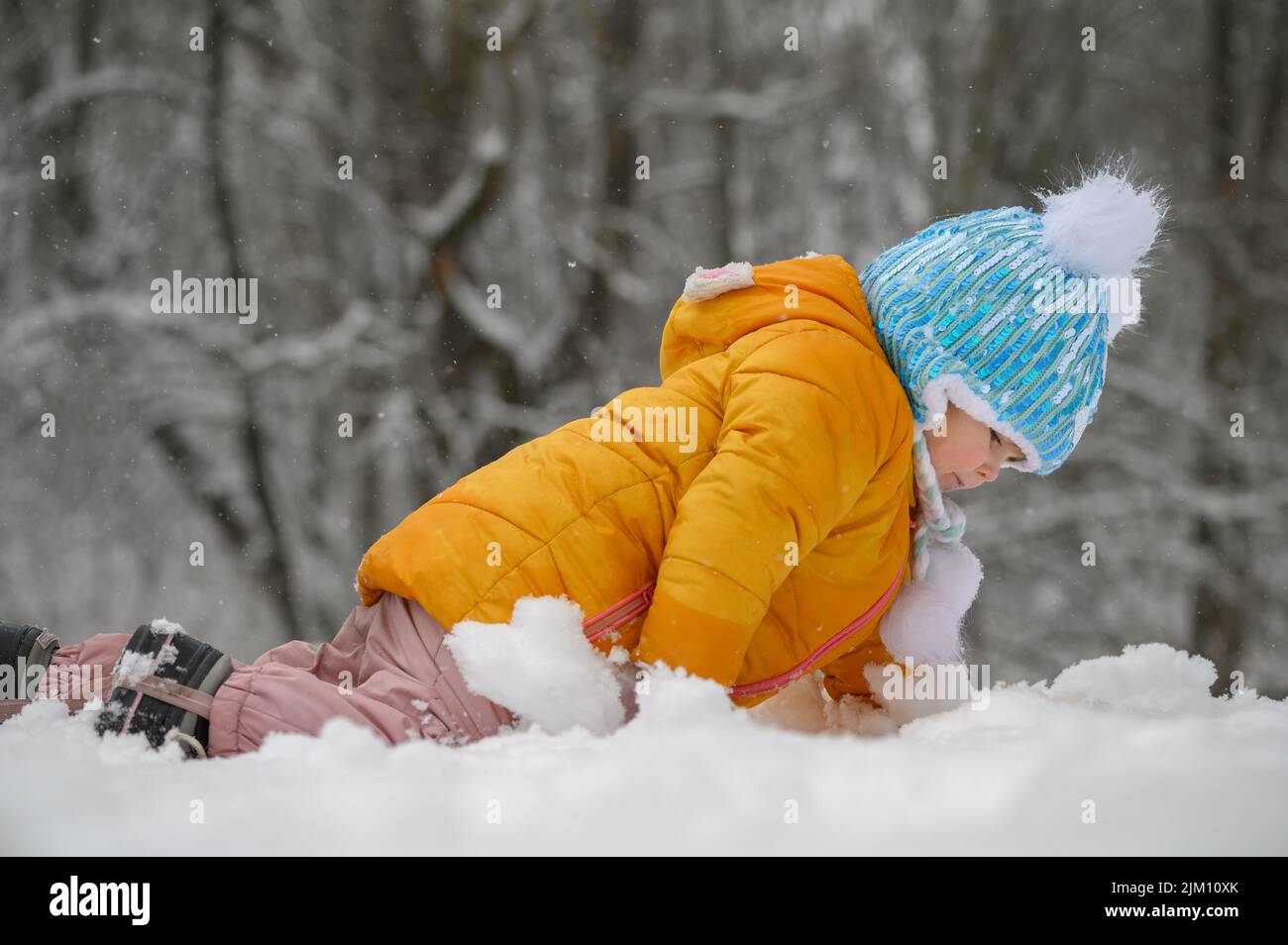 petite fille mignonne jouant dans la neige Banque D'Images