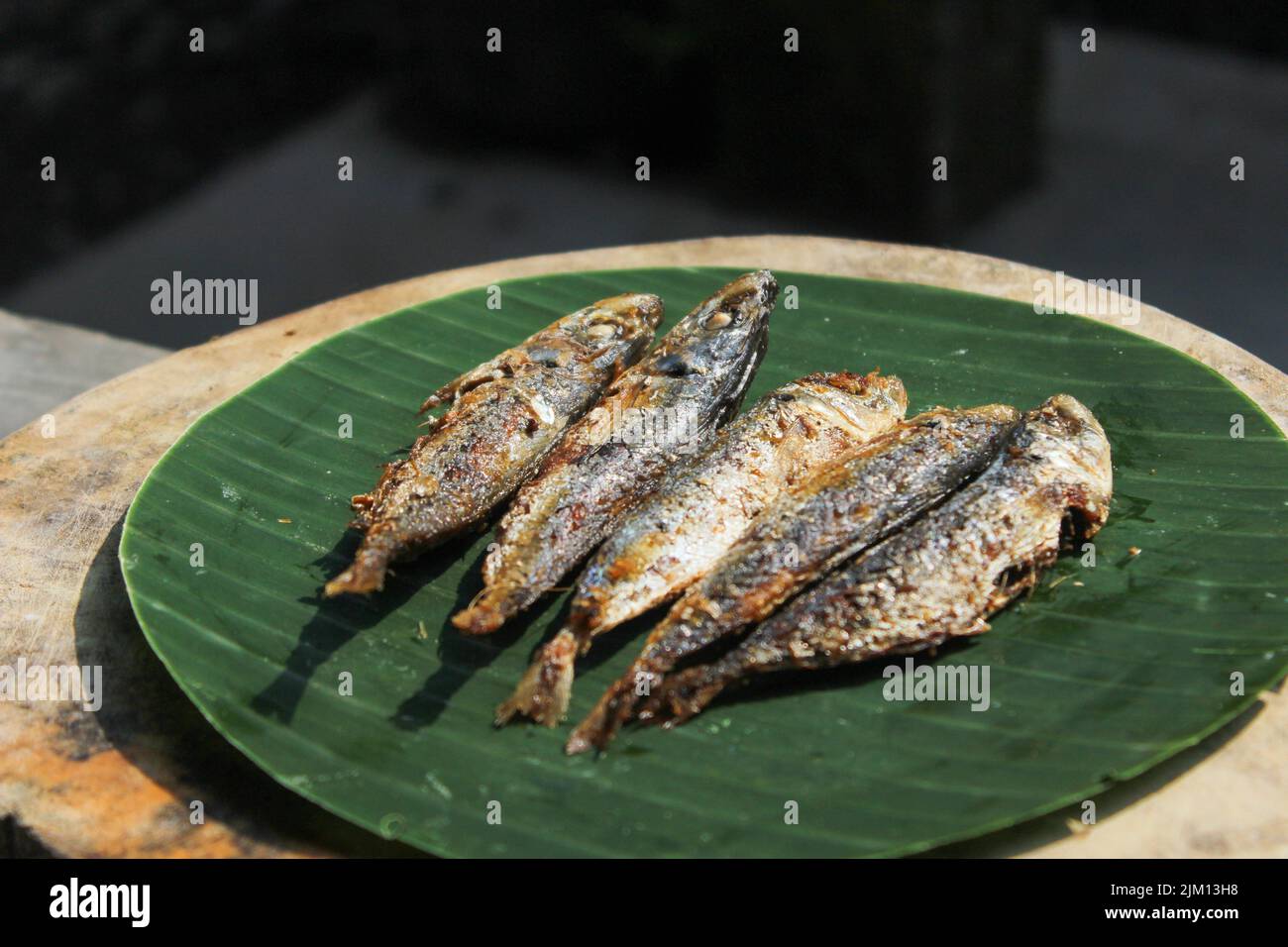 authentique nourriture indonésienne poisson salé frit ou ikan asin gereh sur une surface en bois avec feuille de banane. Banque D'Images