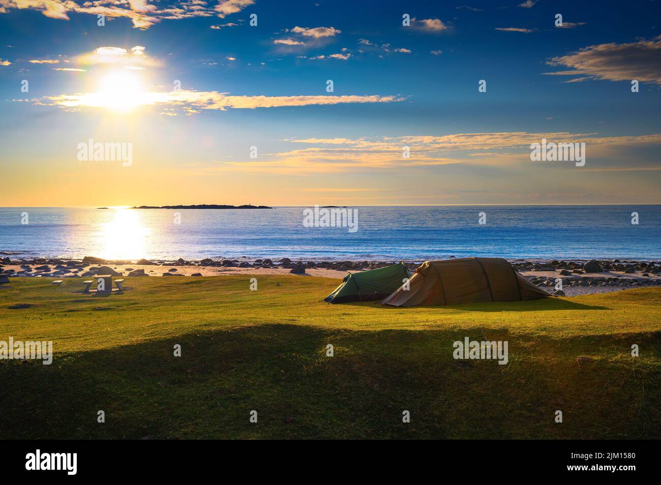 Camping au coucher du soleil avec tentes sur la plage d'Uttakleiv dans les îles Lofoten, Norvège Banque D'Images