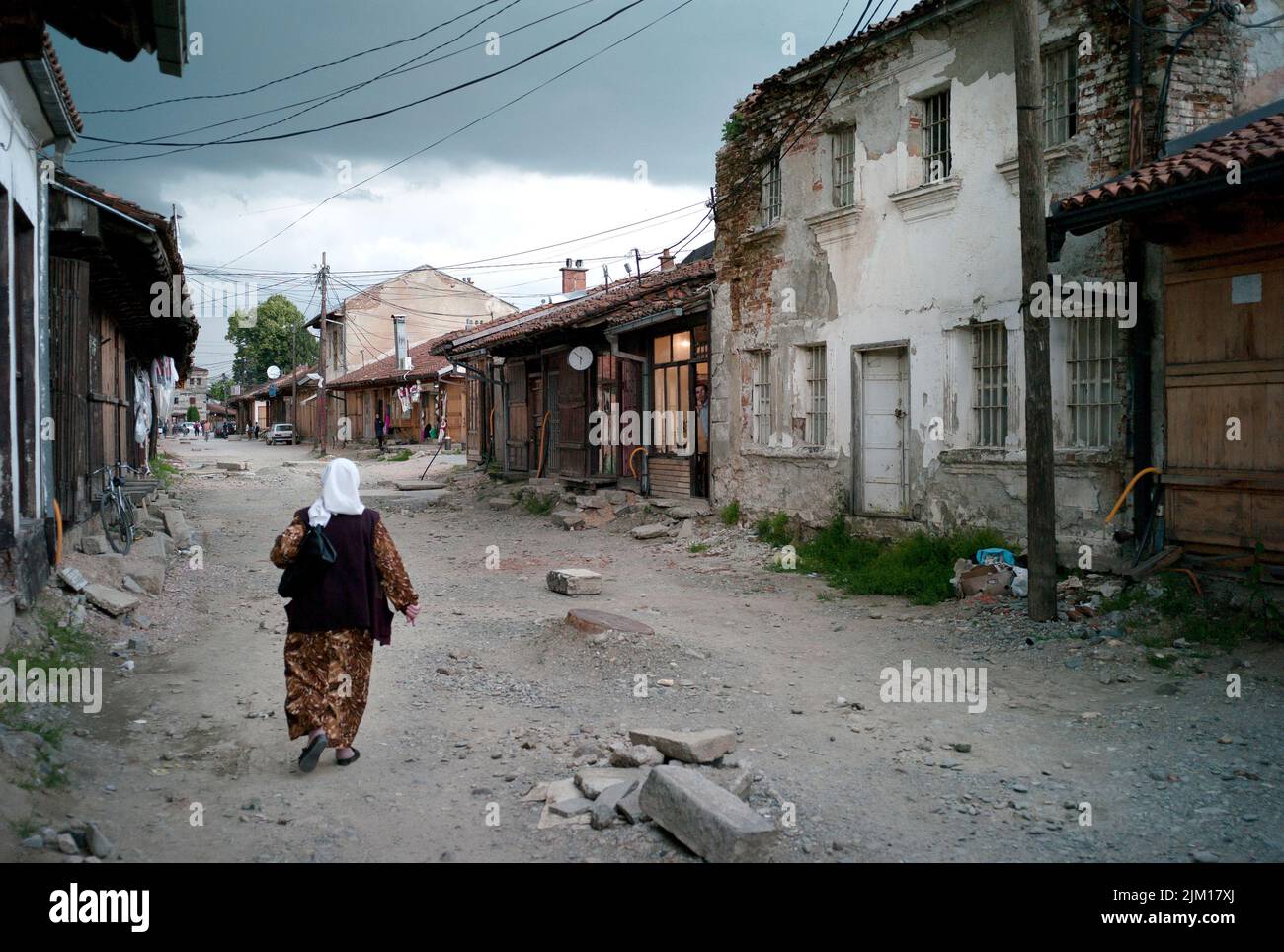 Kosovo, une femme marche sur une route de terre. Banque D'Images
