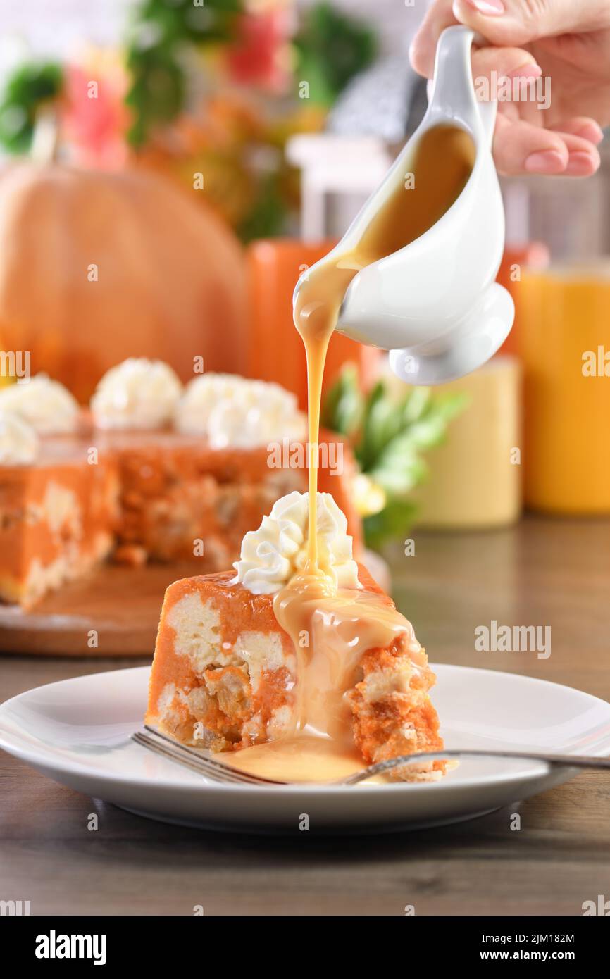 Une tranche de citrouille et une cocotte de fromage cottage avec garniture au caramel sur une assiette. C'est un délicieux dessert rempli de notes automnales. Il est plein de p Banque D'Images