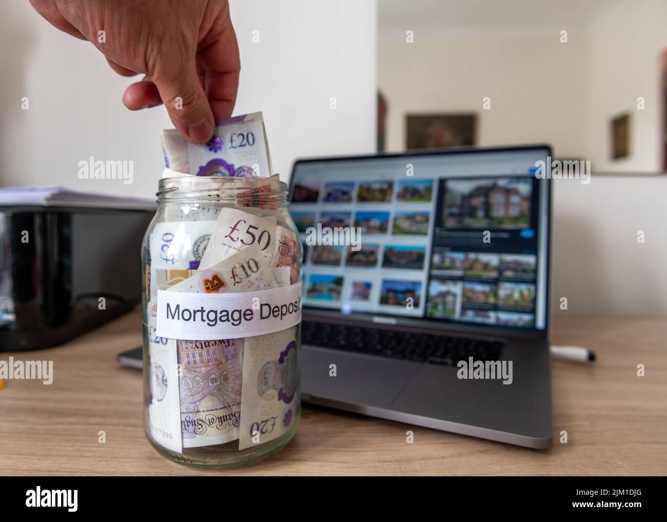 Une personne économisant de l'argent vers un dépôt hypothécaire afin d'obtenir sur l'échelle de propriété et d'acheter une maison. Banque D'Images