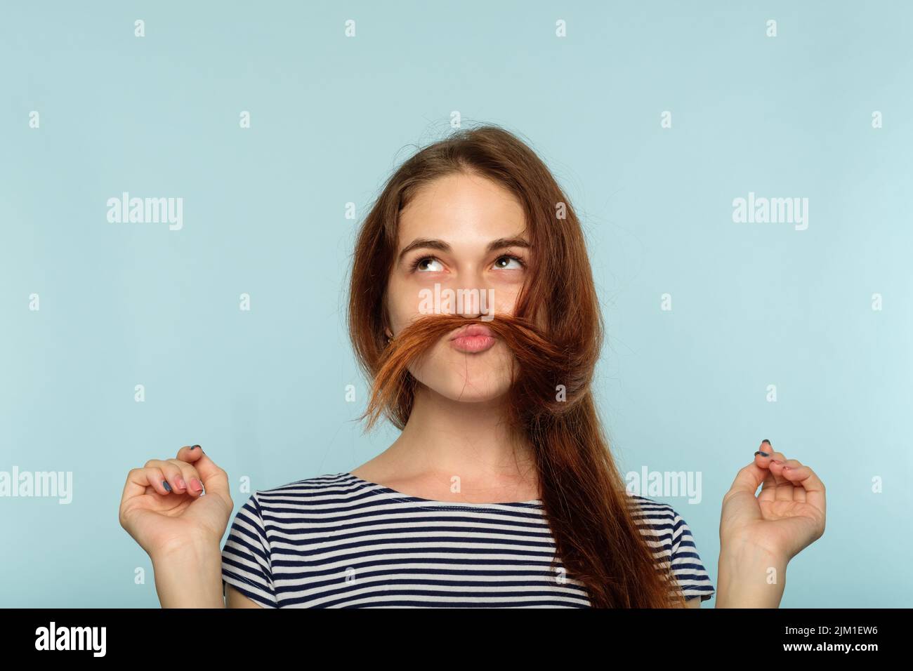 drôle et ludique, insouciante, petite fille, qui se berce les cheveux Banque D'Images