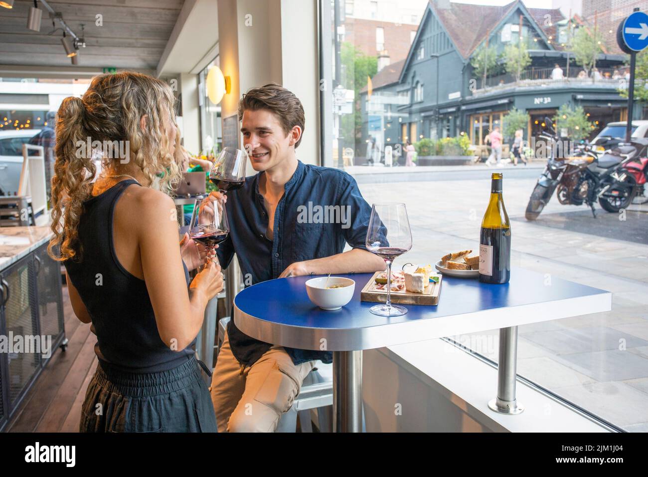 Jeune couple caucasien dégustant du vin rouge au bar à vin Banque D'Images