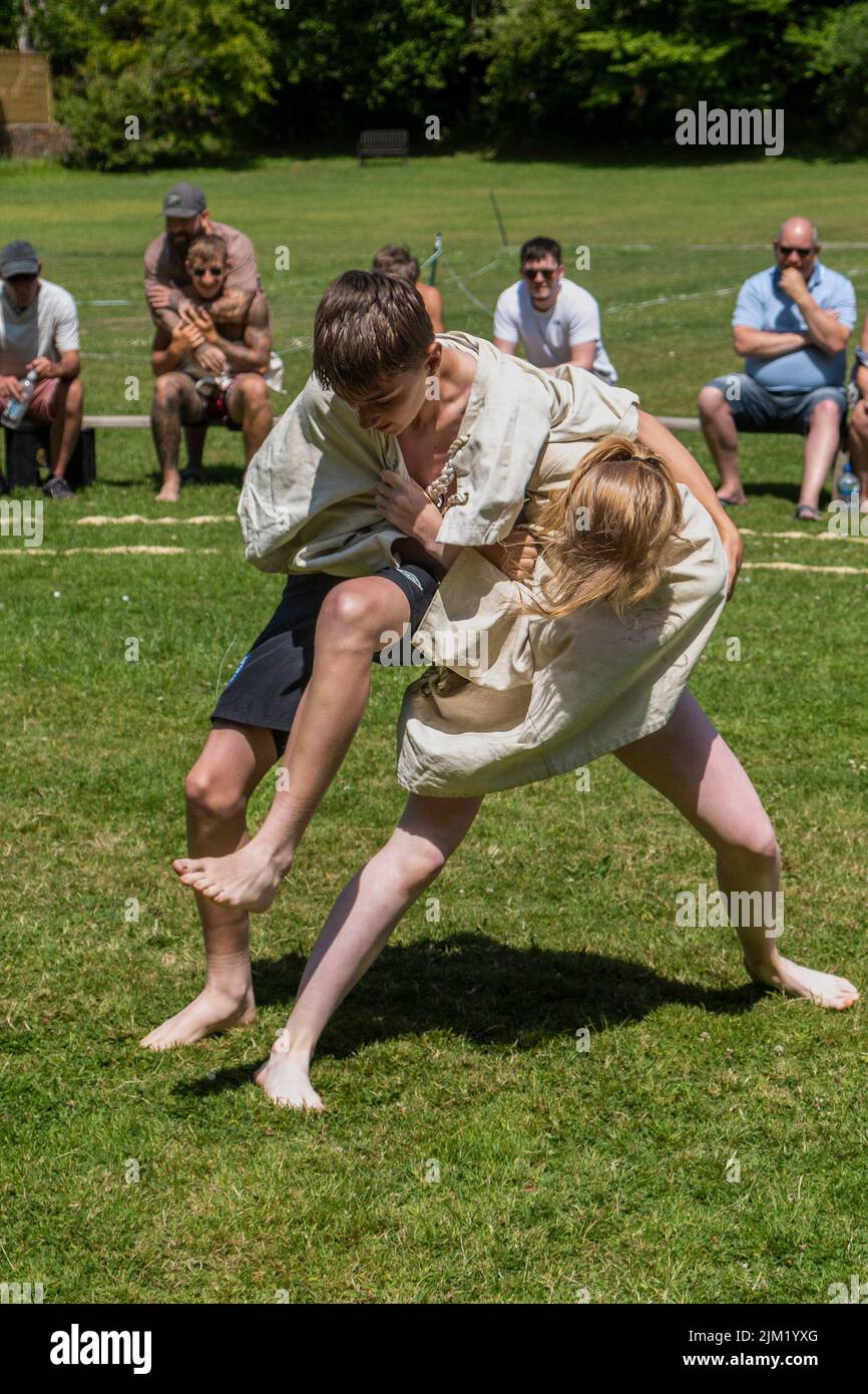 Une jeune adolescente lutte avec un garçon en compétition dans le Grand Tournoi de Wrestling Cornish à St Mawgan, à Pydar, en Cornouailles. Banque D'Images