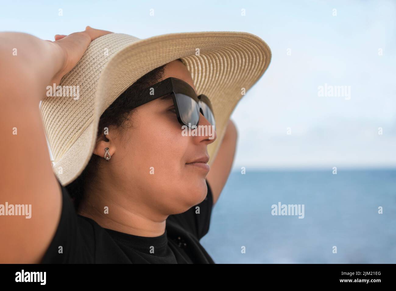 Gros plan d'une femme avec des lunettes de détente près de la mer Banque D'Images