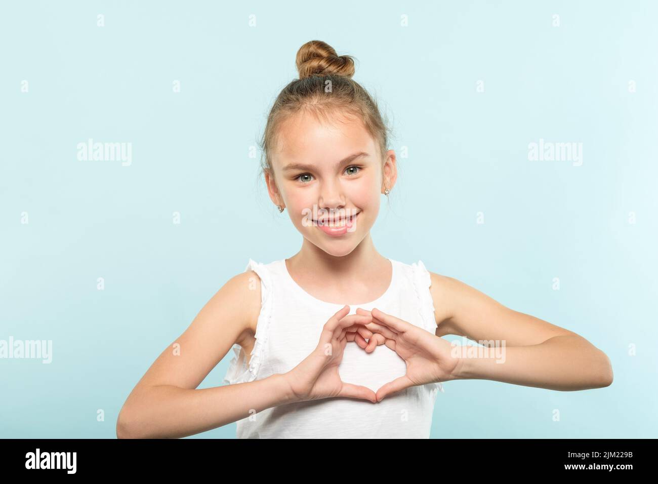 amour émotion souriante fille faisant le coeur forme les mains Banque D'Images