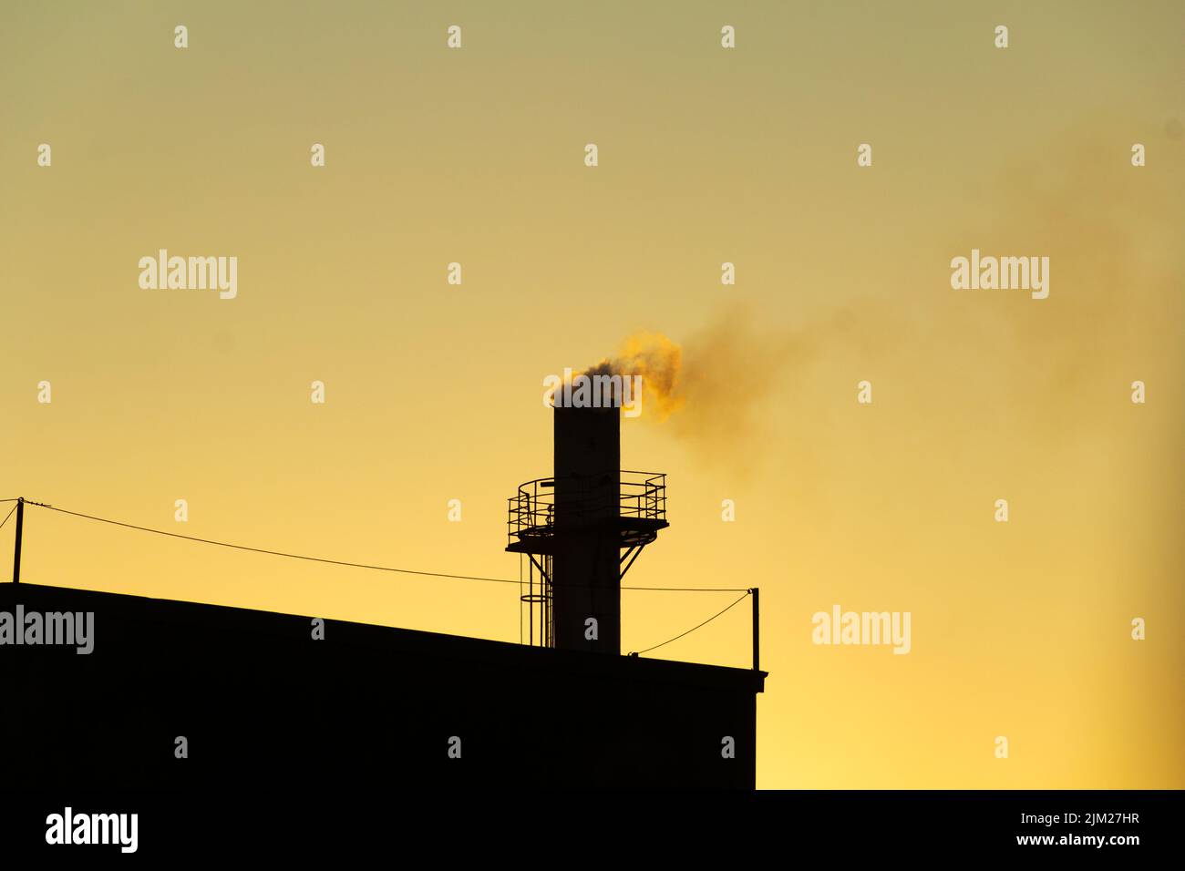 Goiania, Goiás, Brésil – 04 août 2022: Fumée sortant d'une cheminée d'usine. Pollution de l'air de la fumée sortant de la cheminée avec la da dorée Banque D'Images