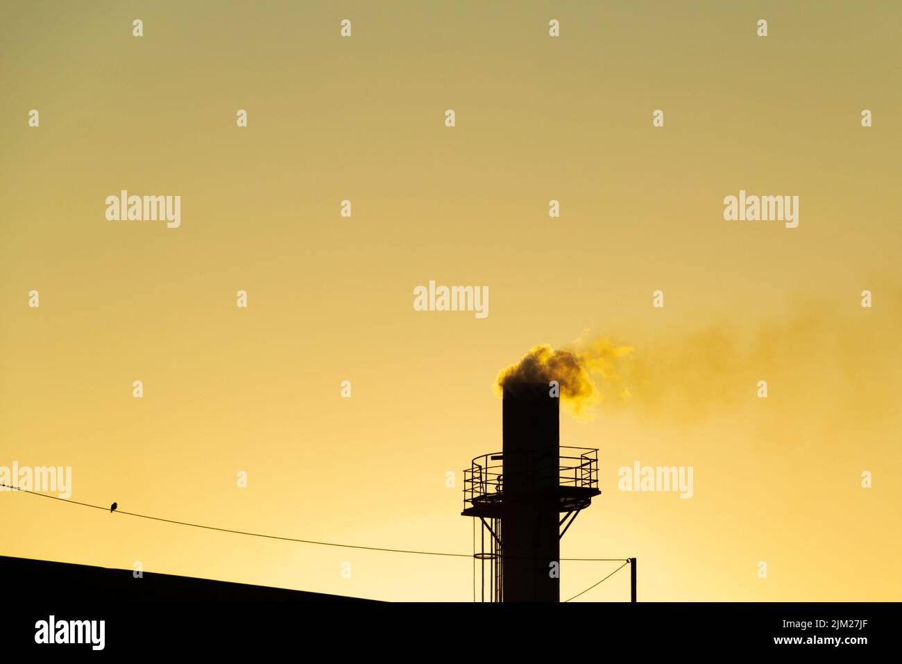 Goiania, Goiás, Brésil – 04 août 2022: Fumée sortant d'une cheminée d'usine. Pollution de l'air de la fumée sortant de la cheminée avec la da dorée Banque D'Images