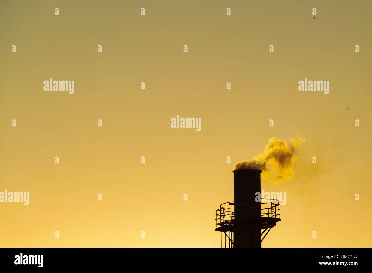 Goiania, Goiás, Brésil – 04 août 2022: Fumée sortant d'une cheminée d'usine. Pollution de l'air de la fumée sortant de la cheminée avec la da dorée Banque D'Images