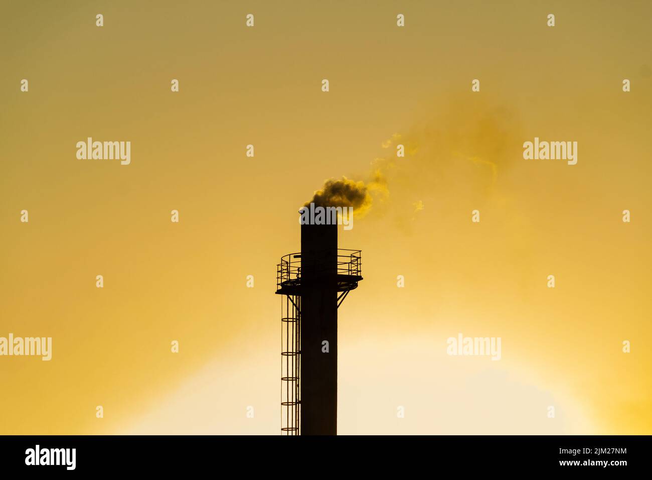 Goiania, Goiás, Brésil – 04 août 2022: Fumée sortant d'une cheminée d'usine. Pollution de l'air de la fumée sortant de la cheminée avec la da dorée Banque D'Images