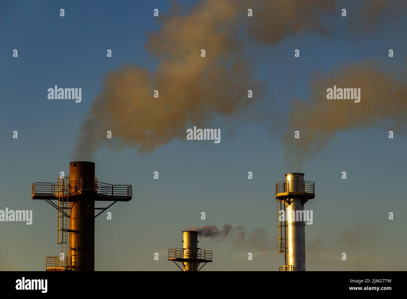 Goiania, Goiás, Brésil – 04 août 2022: Fumée provenant de trois cheminées d'une usine. Pollution de l'air par la fumée sortant de la cheminée. Banque D'Images