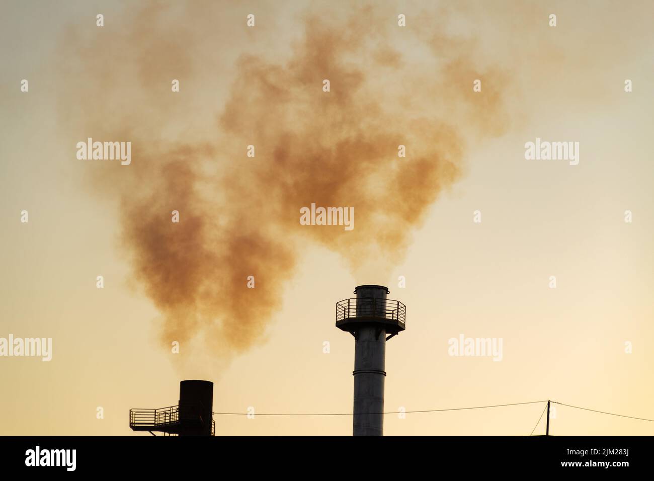 Goiania, Goiás, Brésil – 04 août 2022: Fumée provenant de deux cheminées d'une usine. Pollution de fumée d'usine avec le ciel en arrière-plan. Banque D'Images