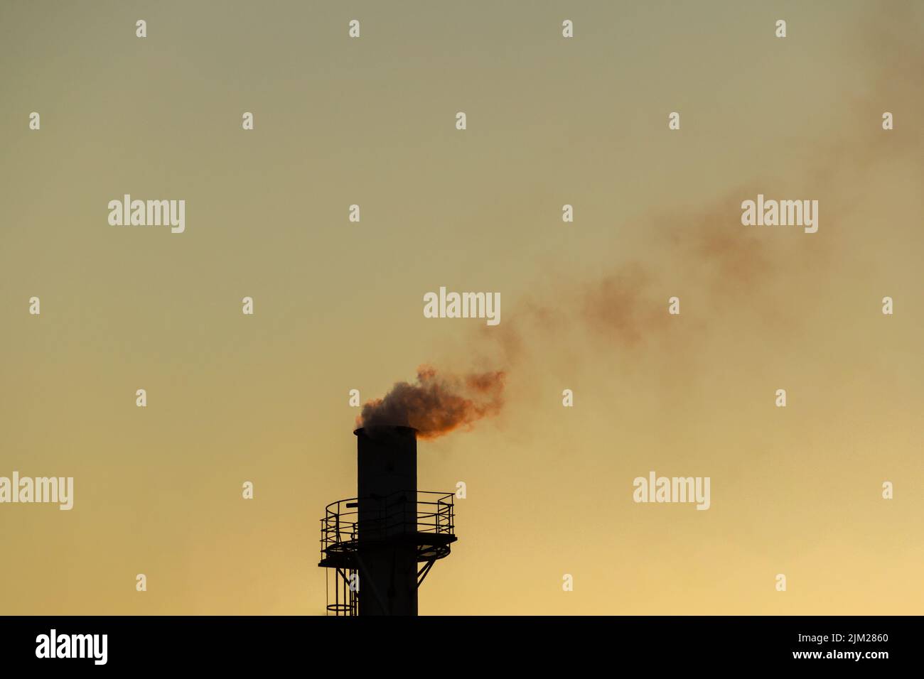 Goiania, Goiás, Brésil – 04 août 2022: Fumée sortant d'une cheminée d'usine. Pollution de l'air de la fumée sortant de la cheminée avec la da dorée Banque D'Images