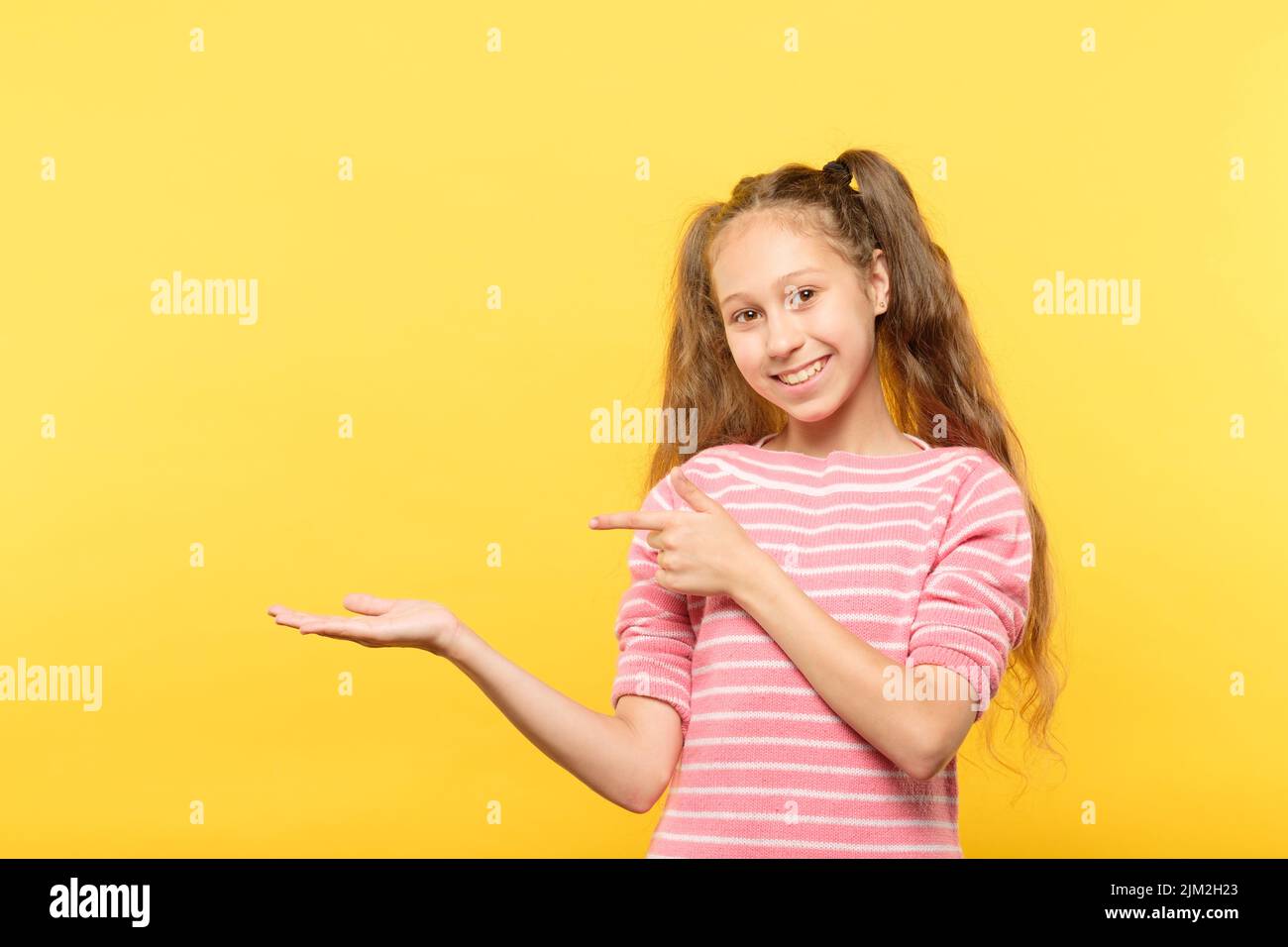 sourire fille tenir point objet virtuel mains vides Banque D'Images