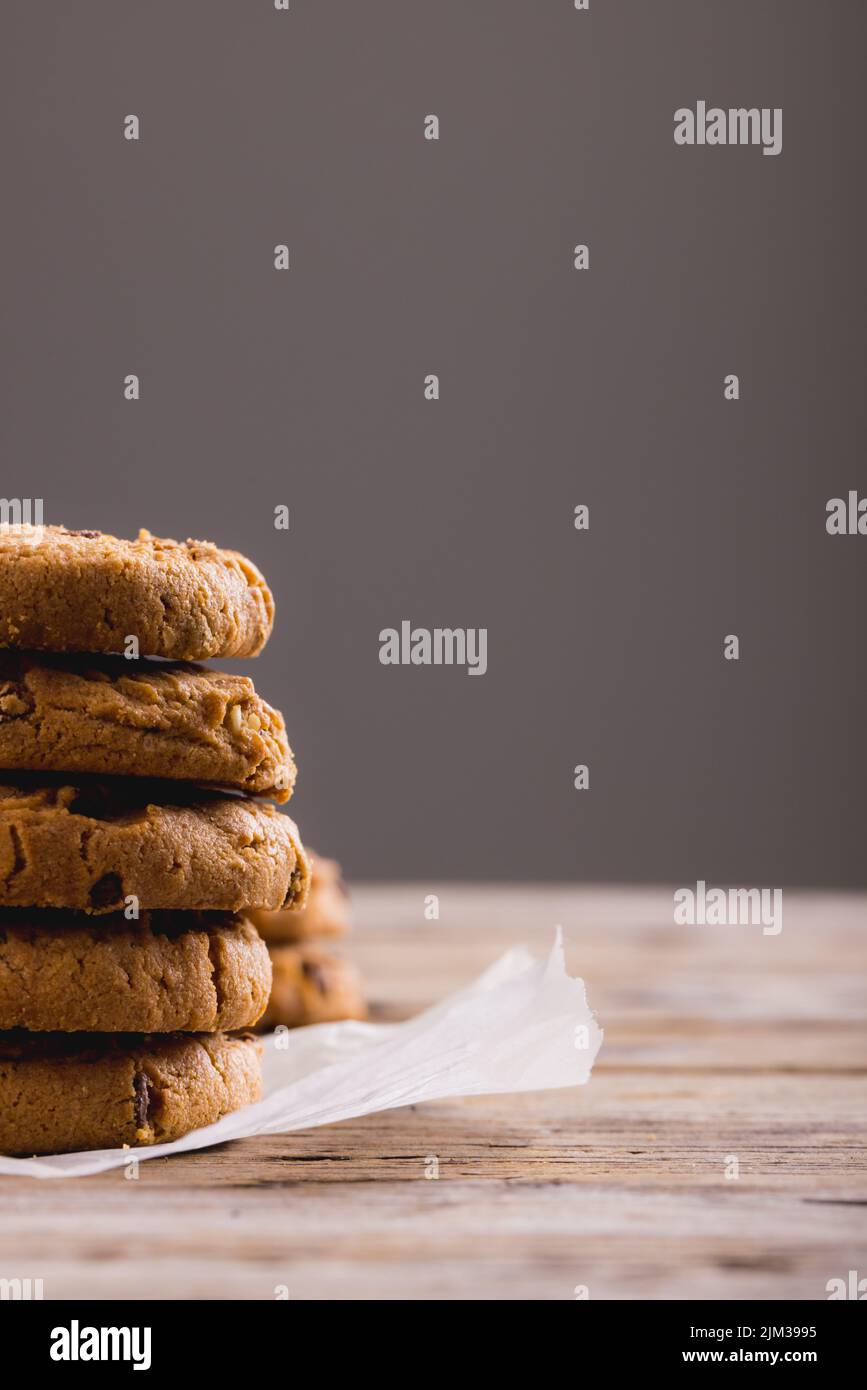 Gros plan des cookies empilés sur du papier parchemin sur fond gris, espace de copie Banque D'Images