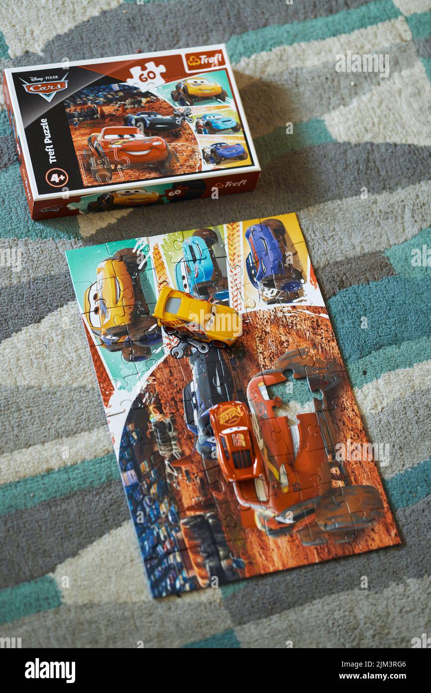 Le Mattel Cruz Ramirez et Lightning McQueen dans un puzzle de Trefl Disney Pixar Cars à côté de la boîte. Banque D'Images