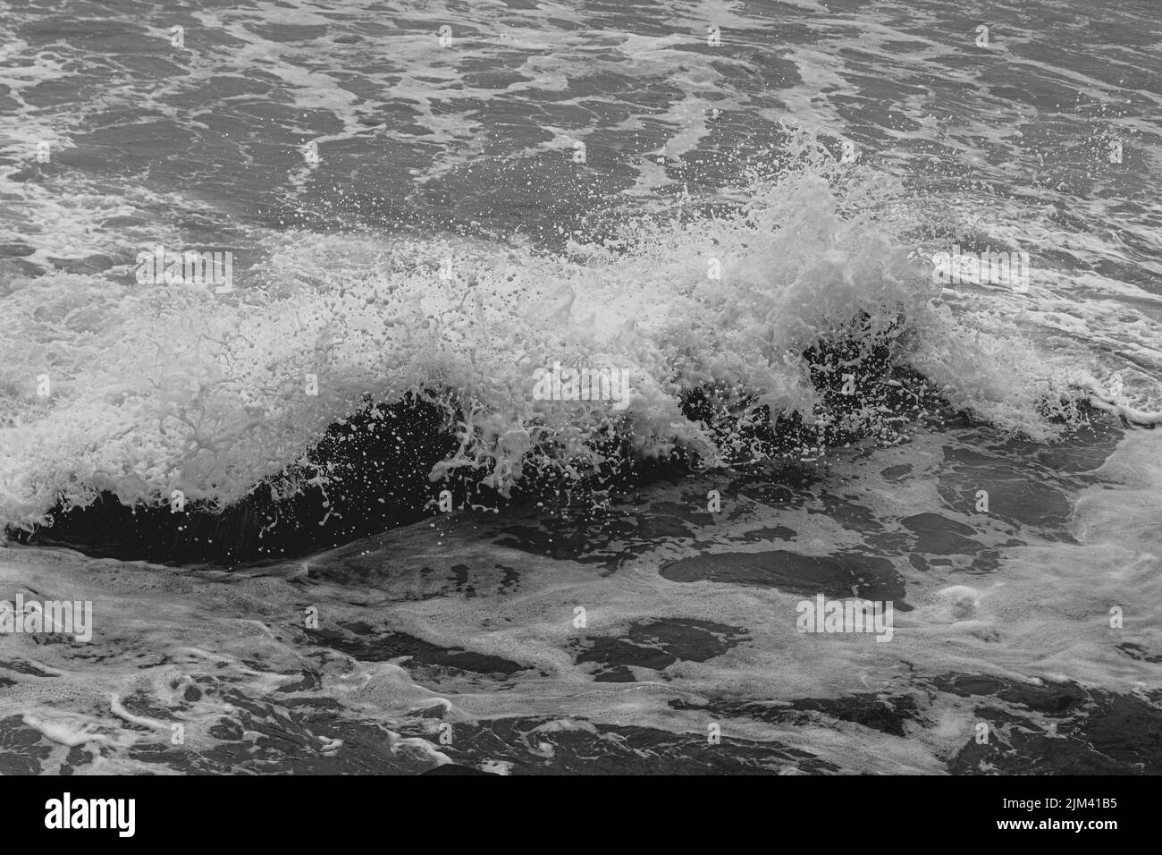 Gros plan d'une vague de mer en noir et blanc Banque D'Images