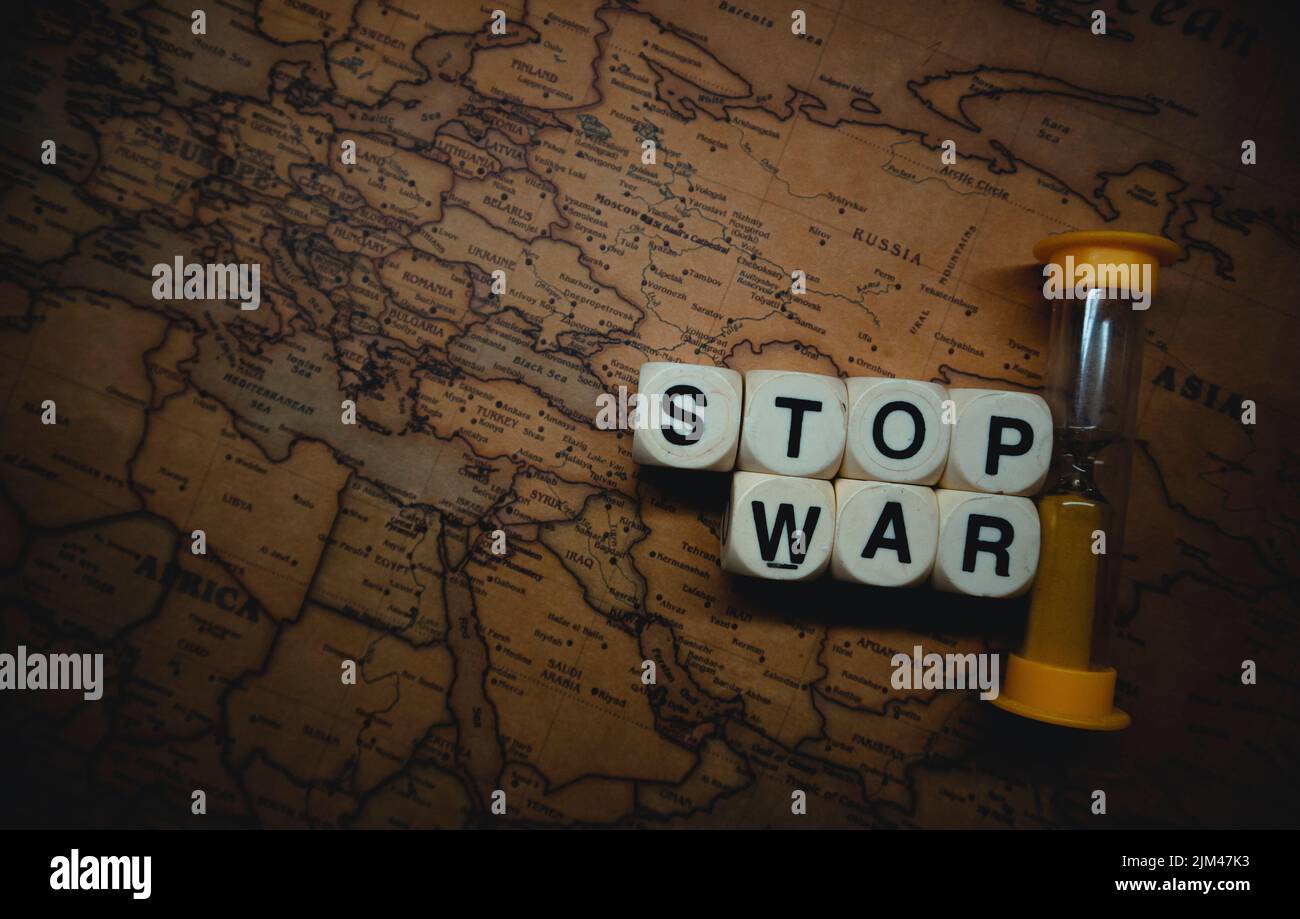 Un gros plan d'un sablier et de mots cubes « top war » placés entre la Russie et l'Ukraine sur une carte du monde Banque D'Images