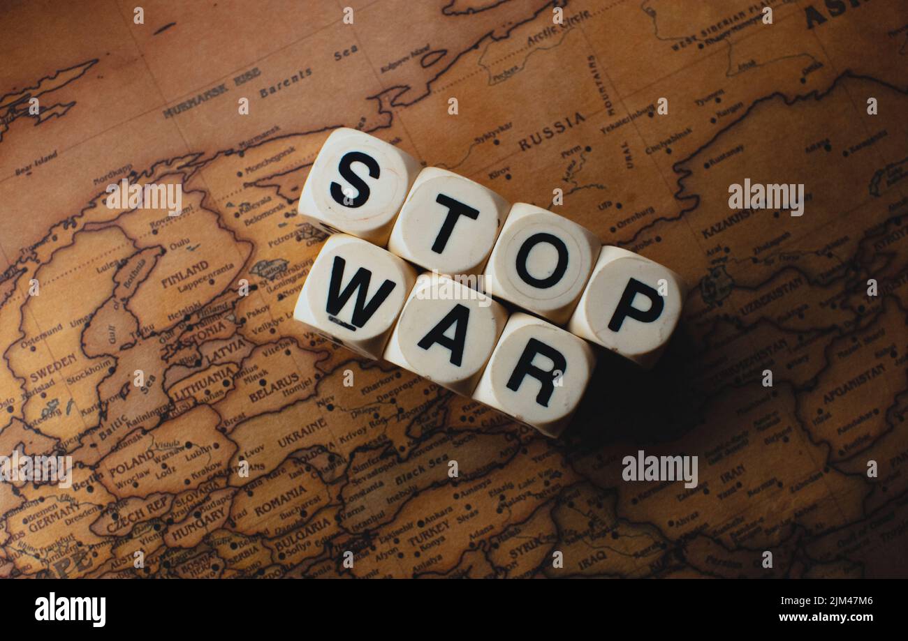 Un gros plan des mots cubes « guerre d'or » placés entre la Russie et l'Ukraine sur une carte du monde Banque D'Images