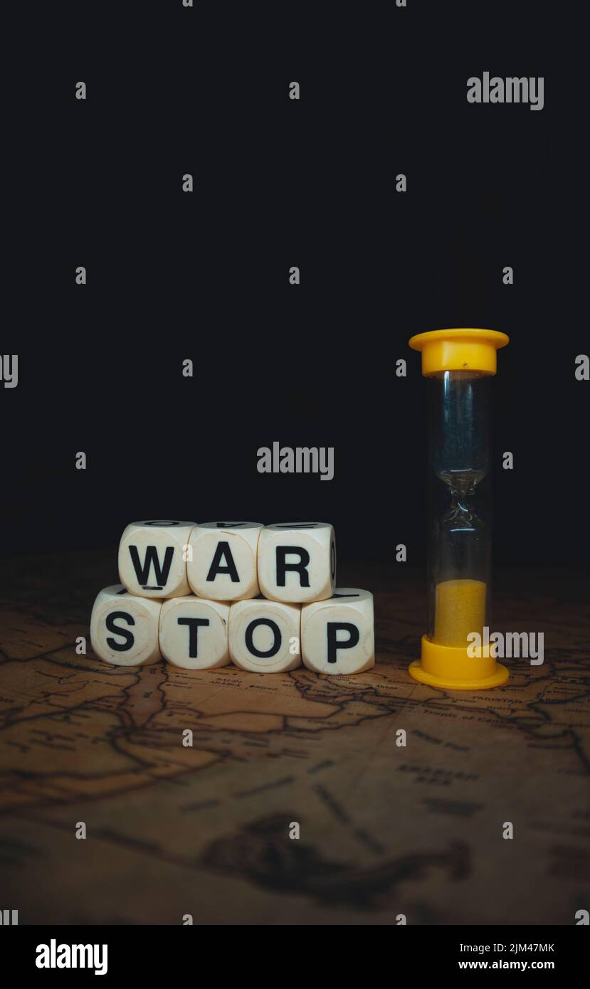 Un gros plan vertical d'un sablier et les mots cubes « top war » sur une carte du monde Banque D'Images