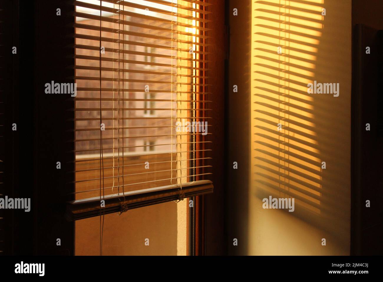 Un soleil éclatant tôt le matin à travers les stores de fenêtre Banque D'Images
