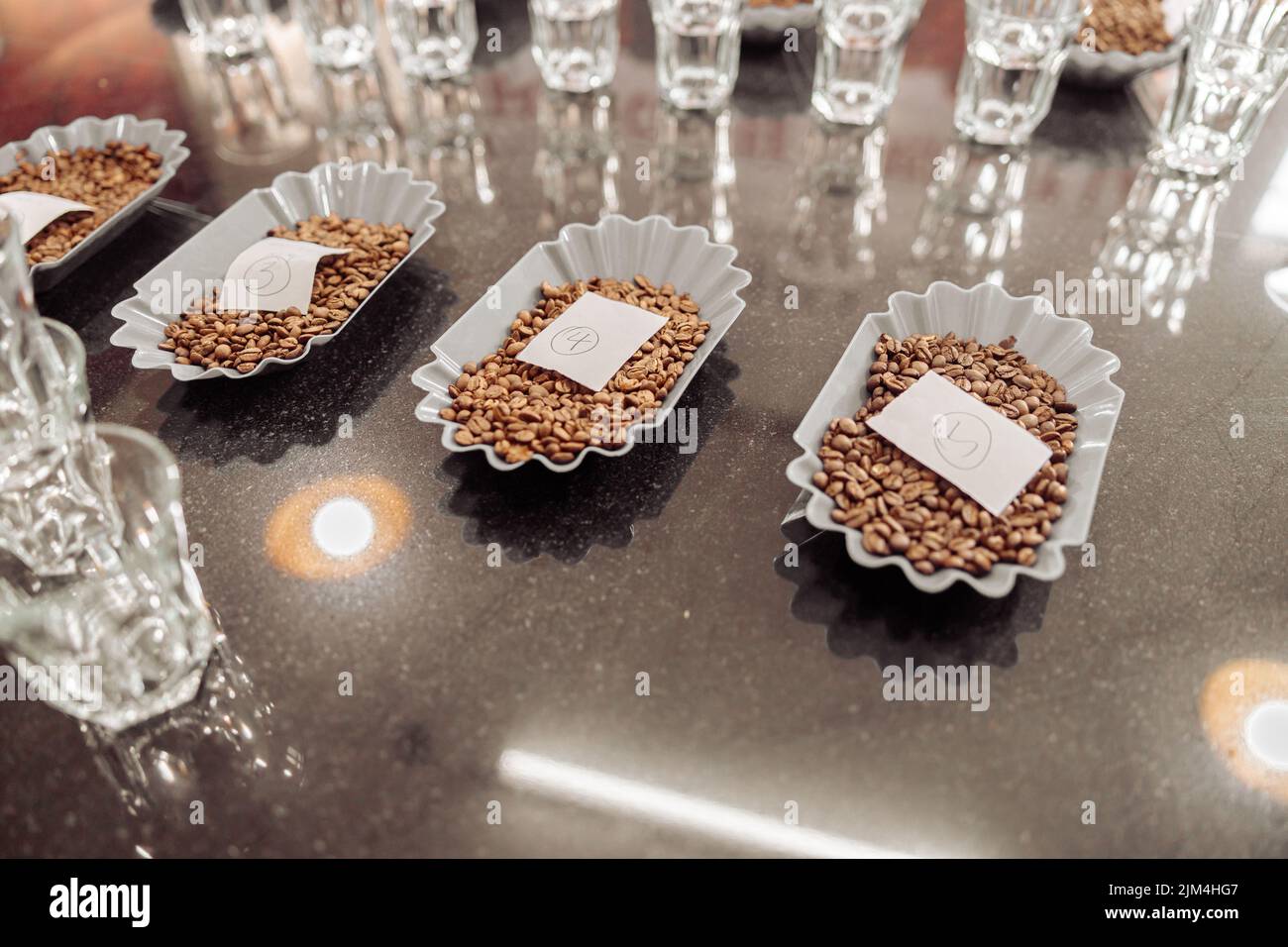 De nombreux verres à eau et bols avec des grains de café sur la table pour la dégustation Banque D'Images