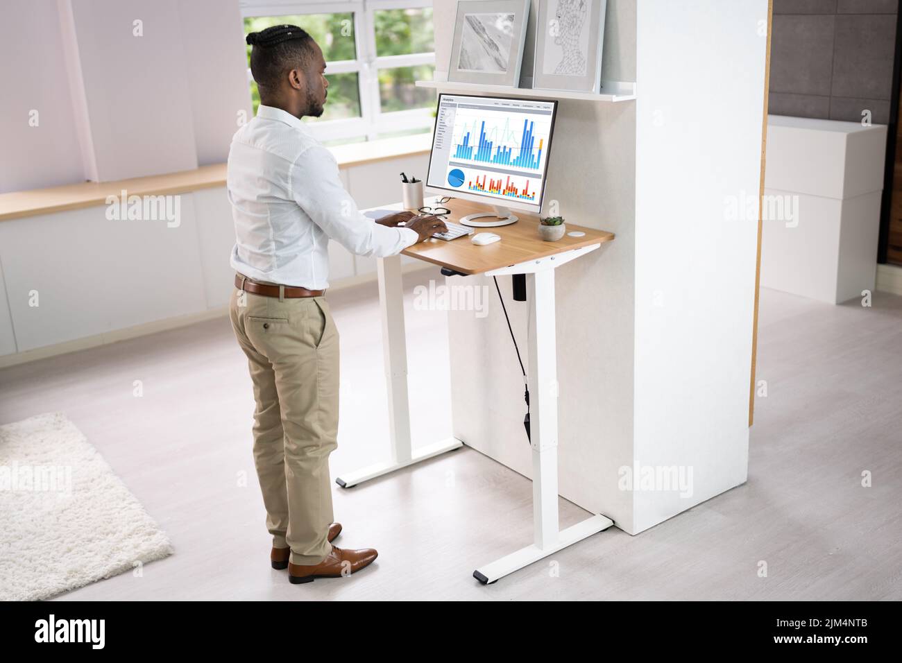 Support de bureau à hauteur réglable dans le bureau à l'aide d'un ordinateur Banque D'Images