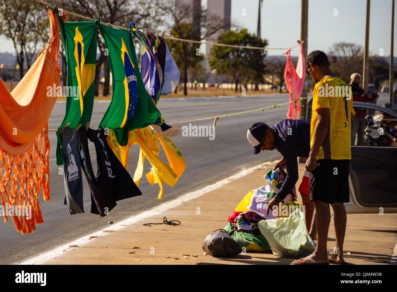 Brasília, District fédéral, Brésil – 23 juillet 2022 : deux vendeurs avec drapeaux brésiliens et t-shirts Bolsonaro exposés sur la rue Brasilia. Banque D'Images