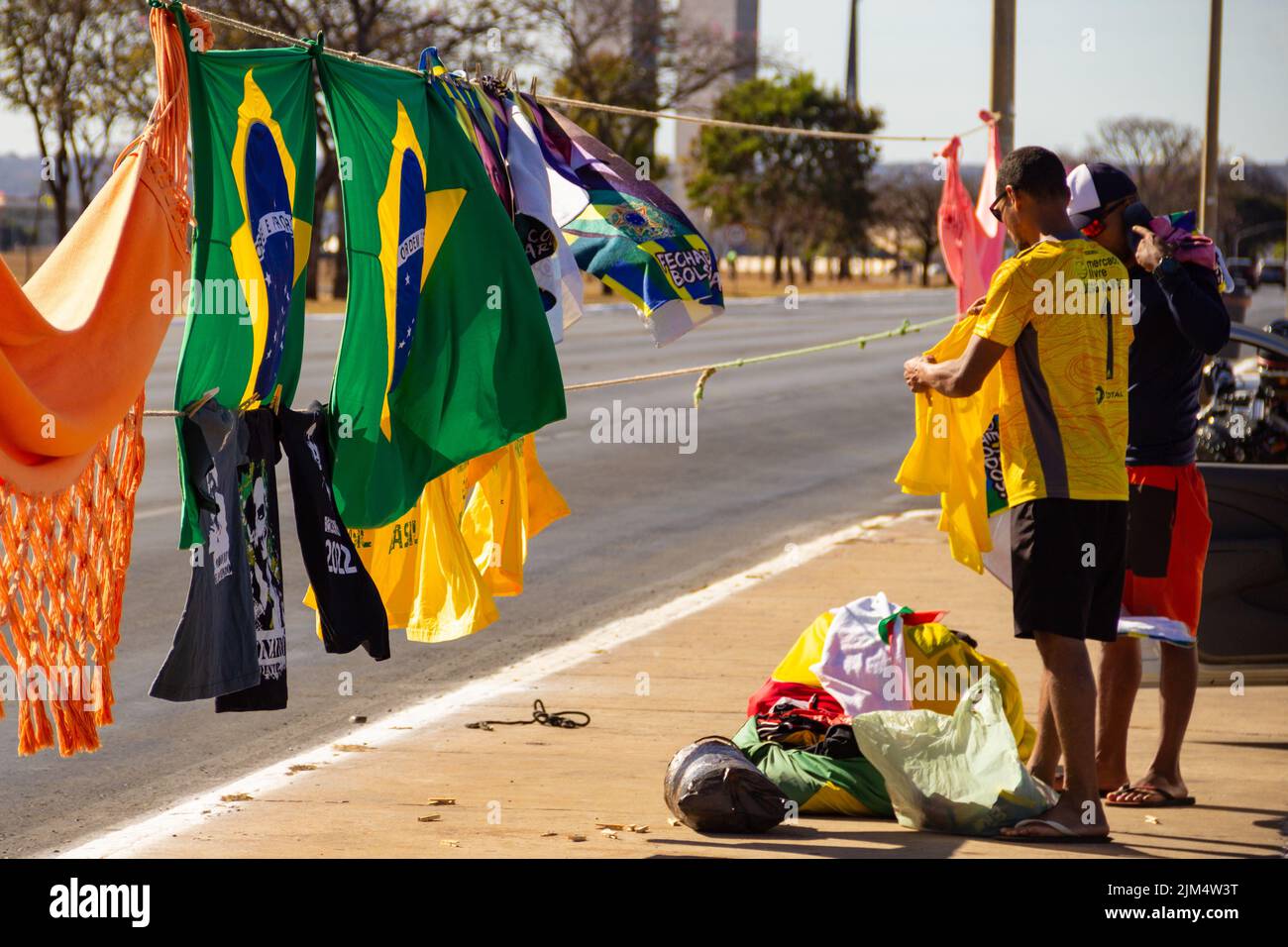 Brasília, District fédéral, Brésil – 23 juillet 2022 : deux vendeurs avec drapeaux brésiliens et t-shirts Bolsonaro exposés sur la rue Brasilia. Banque D'Images