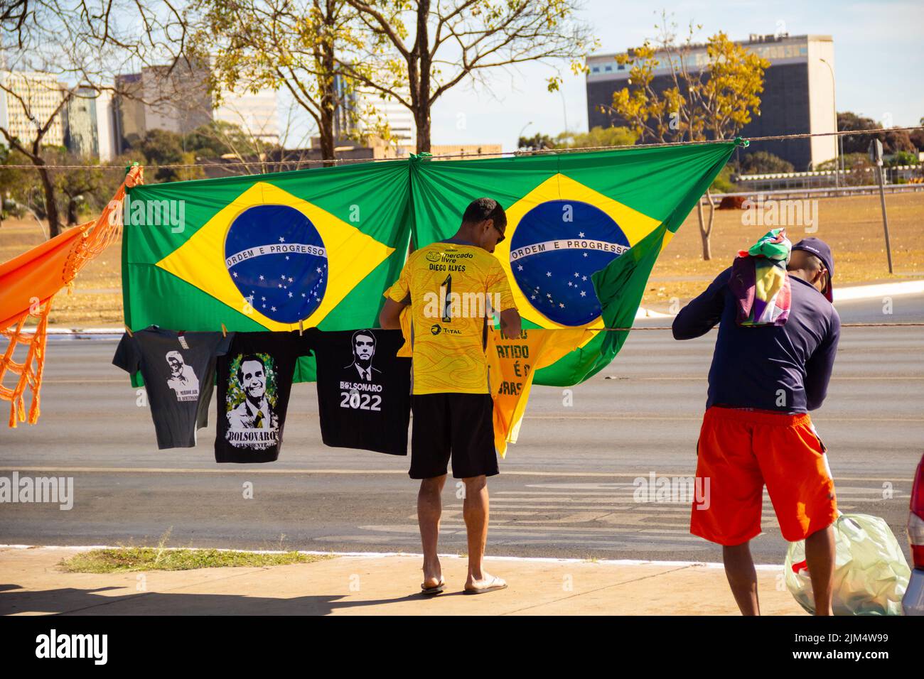 Brasília, District fédéral, Brésil – 23 juillet 2022 : deux vendeurs avec drapeaux brésiliens et t-shirts Bolsonaro exposés sur la rue Brasilia. Banque D'Images