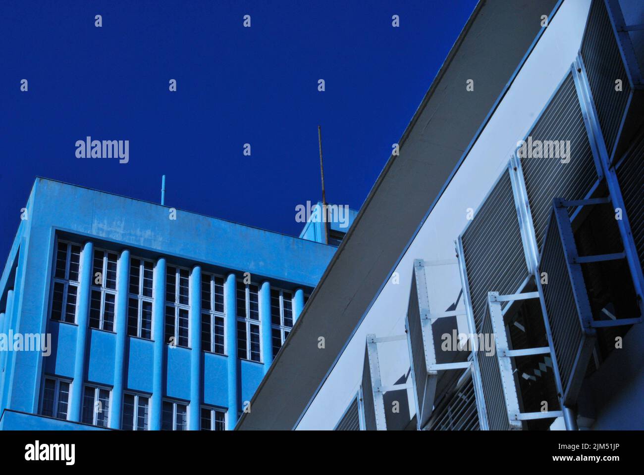 Bâtiment bleu et blanc coupant l'avion avec le ciel en arrière-plan Banque D'Images