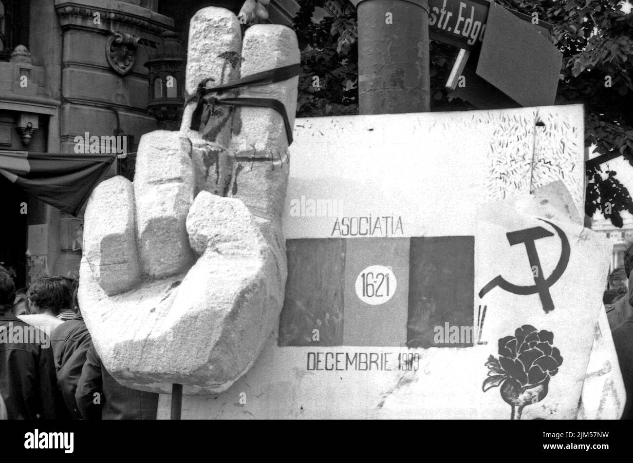 Bucarest, Roumanie, janvier 1990. « Golaniada », une importante manifestation anti-communiste sur la place de l'université après la révolution roumaine de 1989. Les gens se rassembleraient tous les jours pour protester contre les ex-communistes qui ont pris le pouvoir après la Révolution. Sur cette photo, la rose, symbole du nouveau parti au pouvoir, F.S.N., est associée au symbole communiste. Une grande main a été attachée de sorte qu'il ne sera pas en mesure de faire le signe de la victoire, en allusion que la victoire dans la révolution a été volé au peuple. Banque D'Images