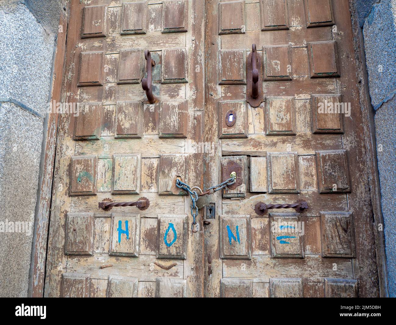 Un gros plan de portes médiévales en bois avec des décorations et des inscriptions en fer. Banque D'Images