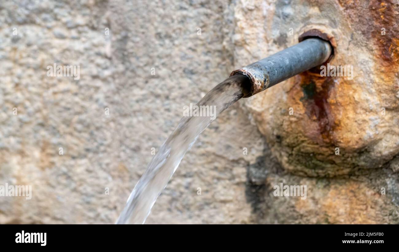 Un gros plan d'une vieille fontaine avec un robinet d'eau romain pour boire Banque D'Images