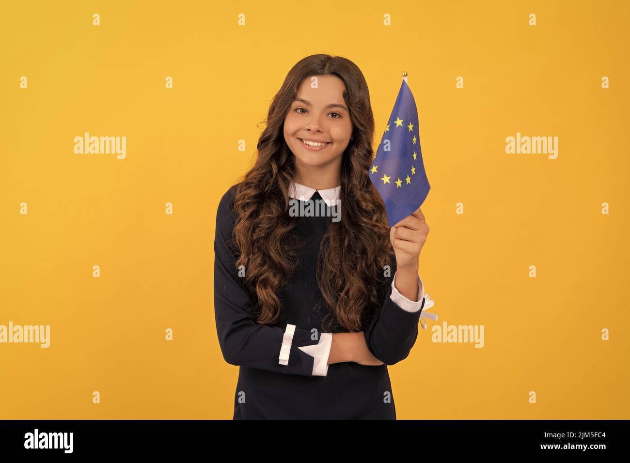 un enfant heureux tient drapeau de l'union européenne fond jaune, union européenne Banque D'Images