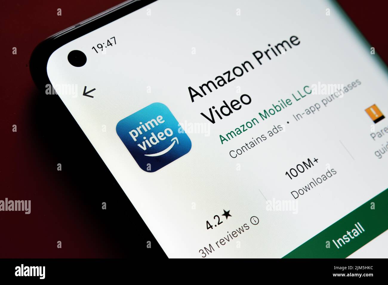 Application vidéo Amazon prime vue dans Google Play Store sur l'écran du smartphone placé sur fond rouge. Gros plan avec mise au point sélective. Stafford, Uni Banque D'Images