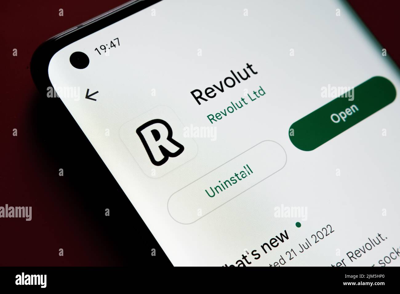 Application Revolut vue dans Google Play Store sur l'écran du smartphone placé sur fond rouge. Gros plan avec mise au point sélective. Stafford, Royaume-Uni Banque D'Images