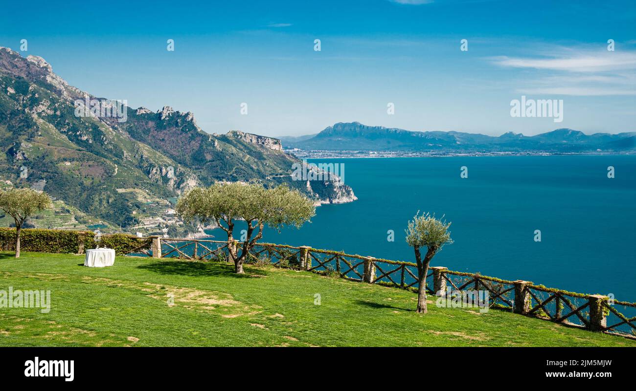 Paysage de fleurs colorées et de palmiers sur la côte amalfitaine de Ravello Italie avec soleil lumineux et ciel bleu Banque D'Images