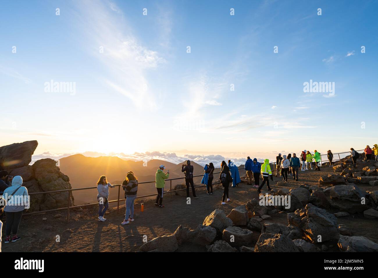 Les touristes se sont rassemblés à un point d'observation au sommet du cratère Haleakala pour observer le lever du soleil. Banque D'Images