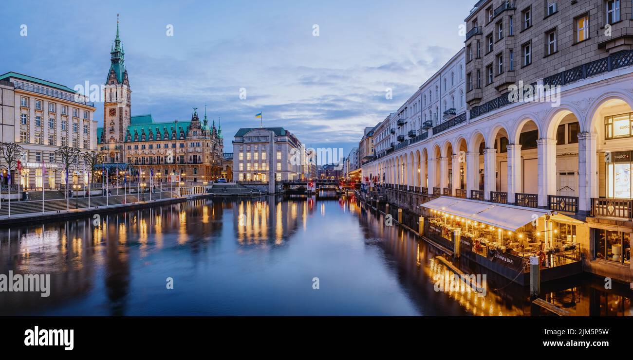 La photo montre l'Alsterarkaden dans la ville de Hambourg à l'heure bleue avec les réverbères allumés. Banque D'Images