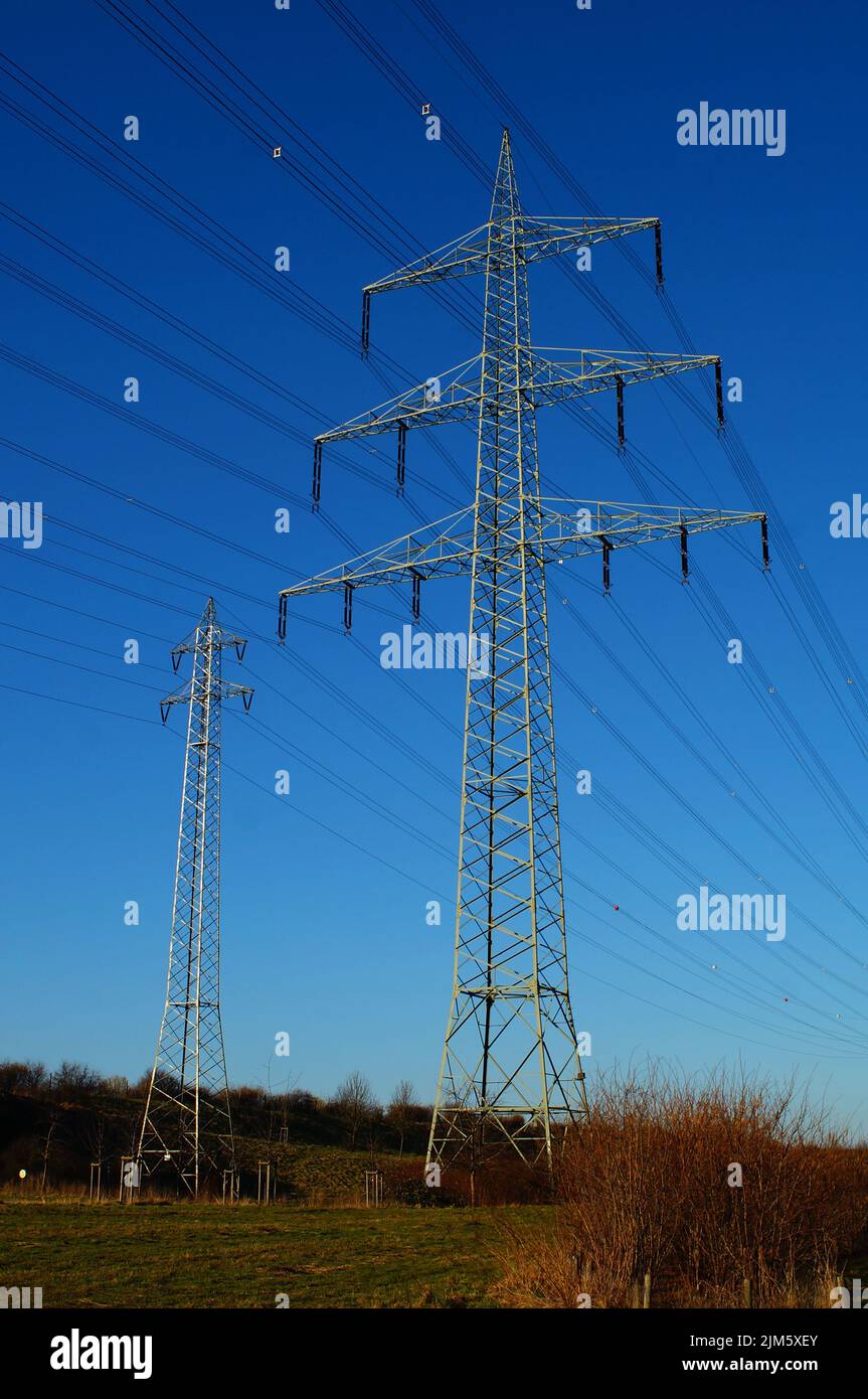 Pylônes haute tension à côté de l'autoroute A5 à Francfort-Riedberg, en Allemagne, contre le ciel bleu du soir. Banque D'Images