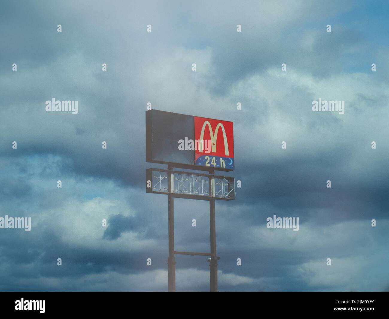 Une affiche publicitaire McDonald's sur le côté de l'autoroute sur fond bleu ciel nuageux Banque D'Images