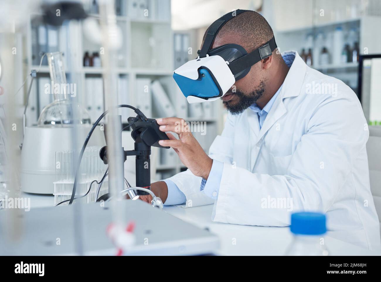 Technologie de pointe pour la recherche médicale avancée. Un scientifique utilisant un casque de réalité virtuelle tout en menant des recherches dans un laboratoire. Banque D'Images