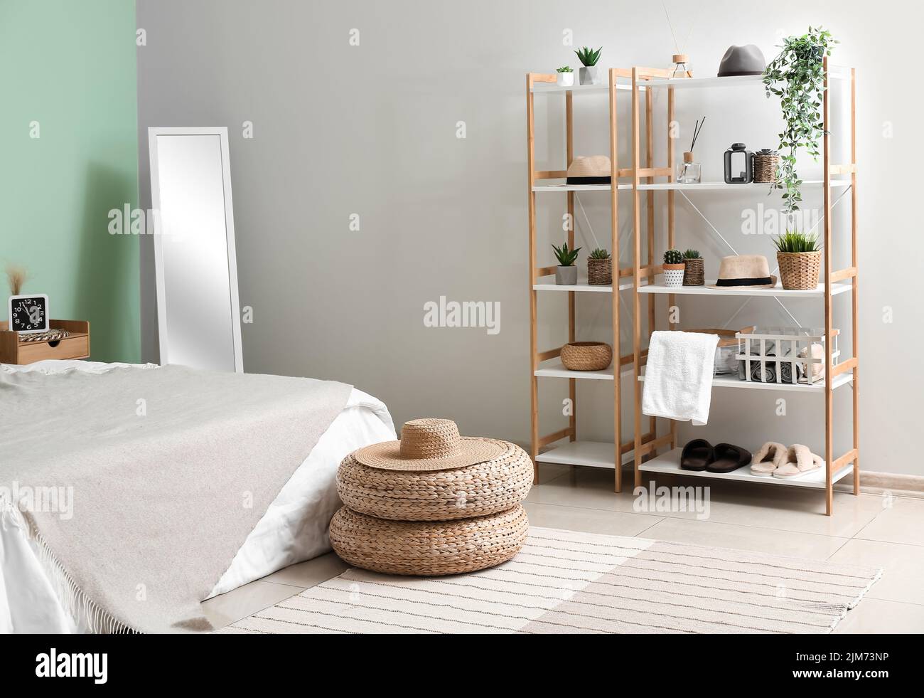 Intérieur d'une chambre confortable avec poufs en rotin, miroir et étagère Banque D'Images