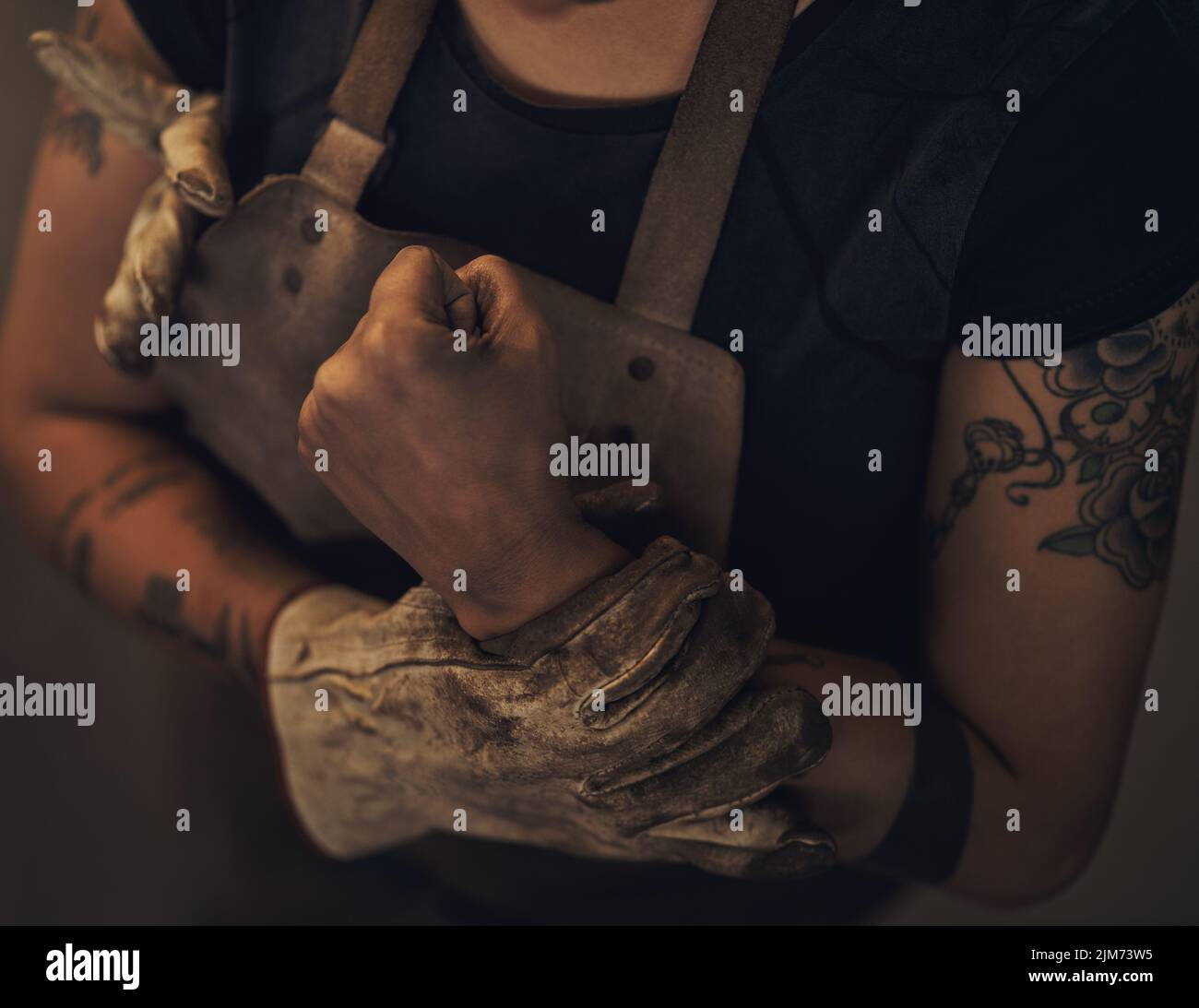 Le risque de travail difficile est réel. Une femme qui souffre de douleurs au poignet en travaillant dans une fonderie. Banque D'Images