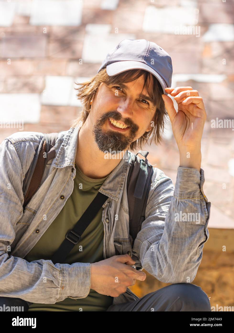 Homme aux cheveux longs et casquette bleue regardant la caméra, concept de  voyage Photo Stock - Alamy