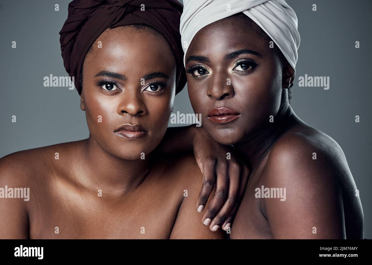 Nous avons su préserver notre magnifique patrimoine et nos traditions. Studio portrait de deux belles jeunes femmes posant sur un fond gris. Banque D'Images