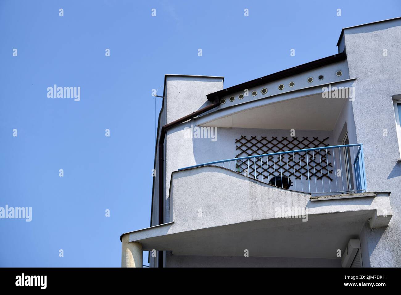 Un balcon au sommet d'un bâtiment en pierre grise sur fond bleu ciel Banque D'Images