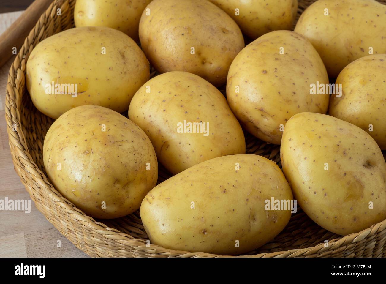 Pomme de terre crue dans un bol en osier Photo Stock - Alamy